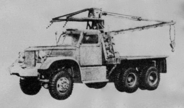 Ein Schwarz-Weiß-Foto eines großen, vierrädrigen Lkw mit einem Kran auf seinem flachen Anhänger, der als erstes Schwerlastfahrzeug gilt.