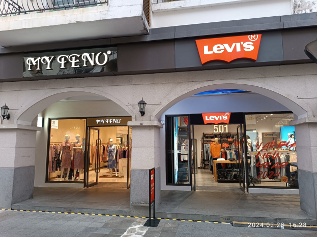 Ladenfront des Levi's-Kleidungsgeschäfts mit Schaufensterpuppen, Kleiderauslagen und einer sichtbaren Straße unten.