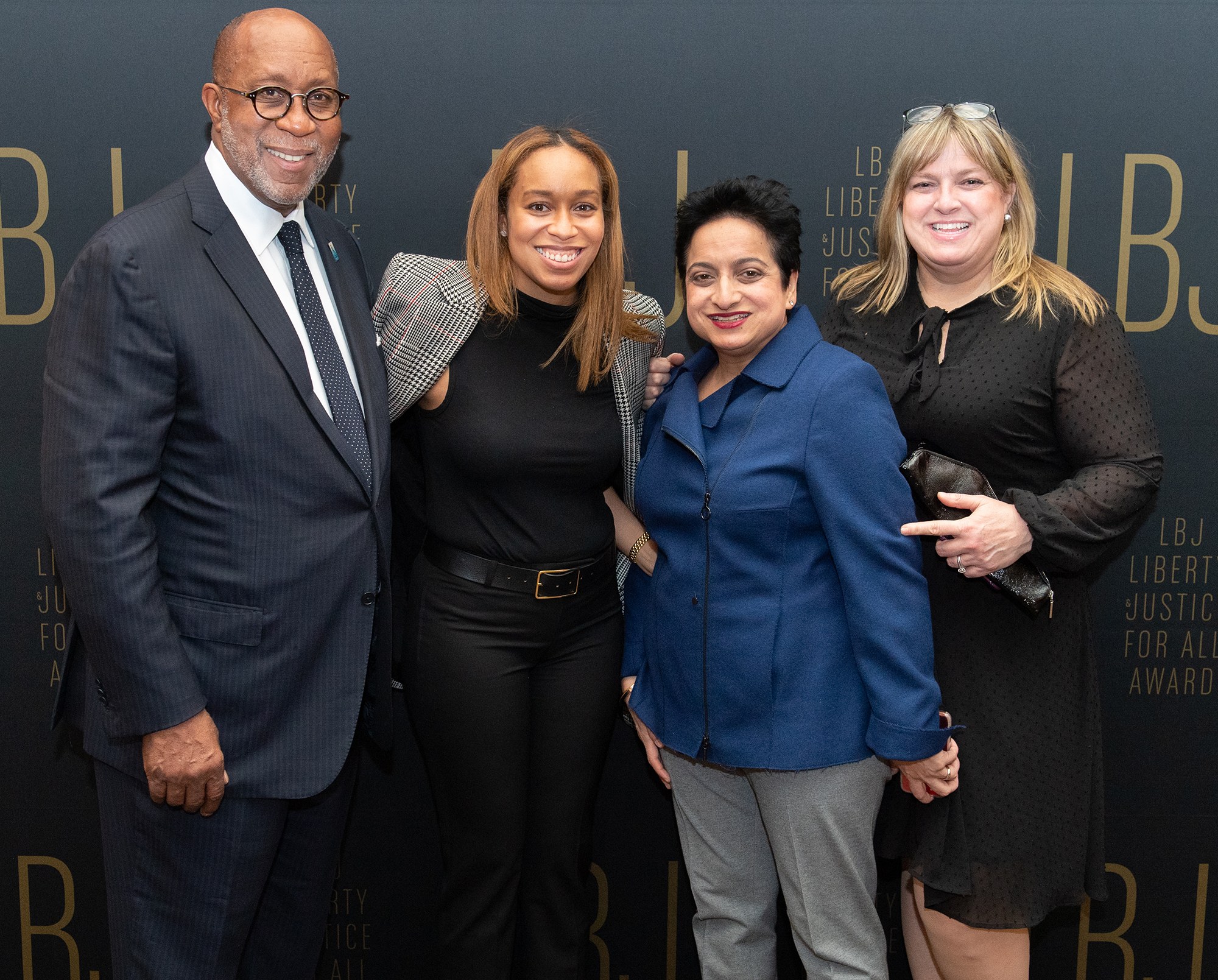 Vier Personen auf einem roten Teppich bei der "Liberty Justice for All Awards"-Veranstaltung, die für ein Foto posen.