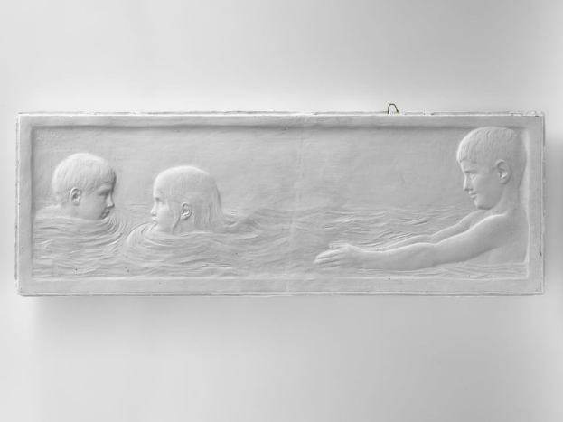 Schwarzes und weißes Foto von drei Kindern, die im Wasser schwimmen, mit einer Wand im Hintergrund, wobei ein Kind in der Mitte zu sehen ist.