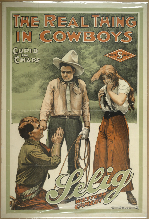 Plakat an einer Wand mit drei Personen, zwei Männer in Cowboyhüten und eine Frau in einem langen Kleid, mit der Aufschrift "The Real Thing in Cowboys" darüber auf einem hellgelben Hintergrund.