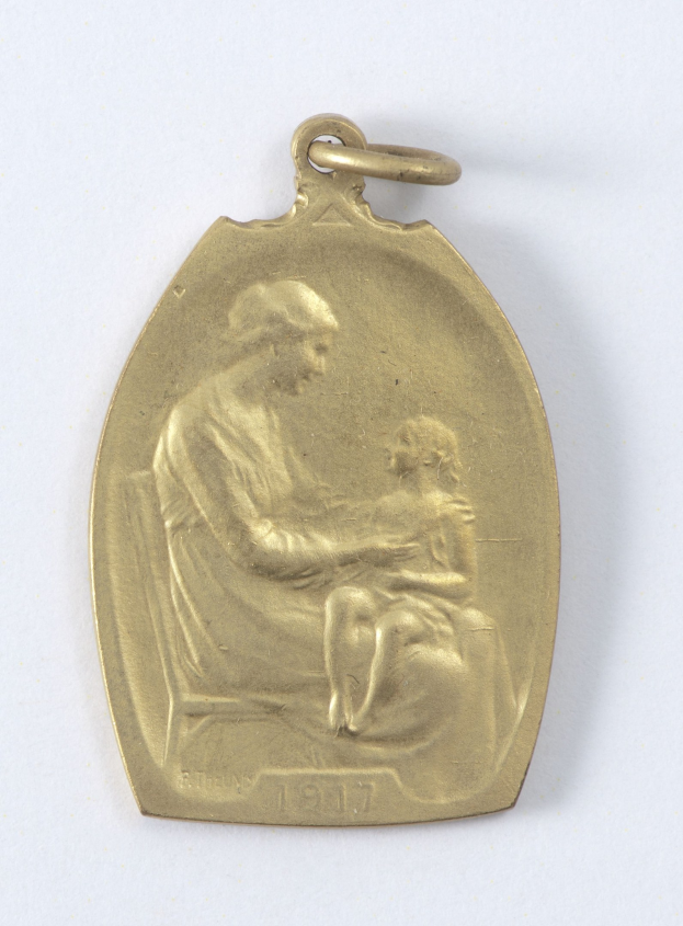 Goldmedaille mit Relief einer Frau in weißem Kleid mit Haarknoten, die ein Kind hält, beide schauen sich sanft an, mit der Inschrift "Mutter und Kind."