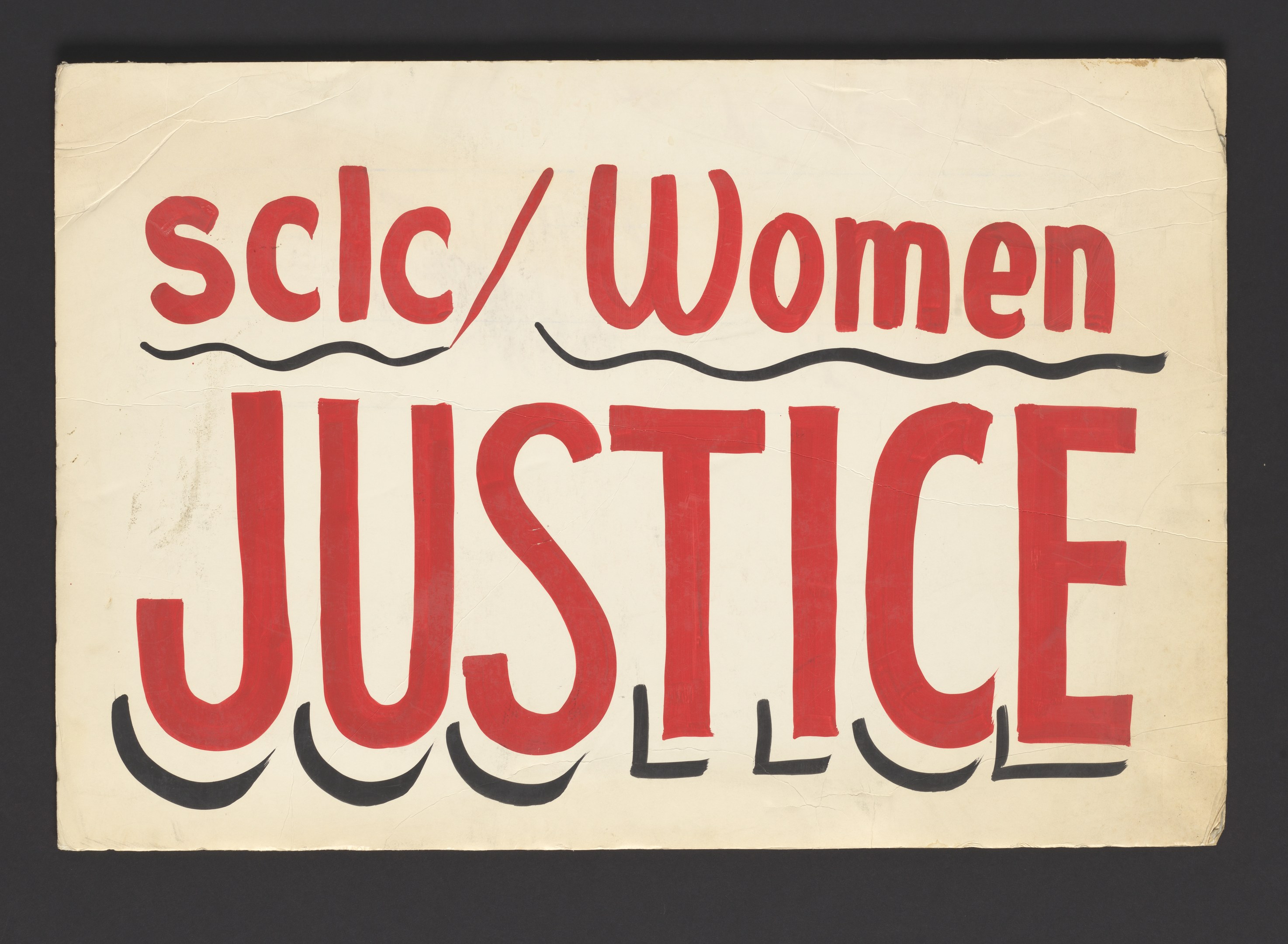 Ein Plakat mit den Worten 'scic/Frauenjustiz' in fetter schwarzer Schrift in der Mitte auf einem weißen Hintergrund, eingerahmt von einem schwarzen Rand.
