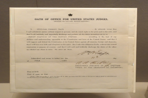 Ein Blatt Papier mit dem Text "Eid für Bundesrichter der Vereinigten Staaten" darauf, das auf einem Tisch vor einer Wand liegt.