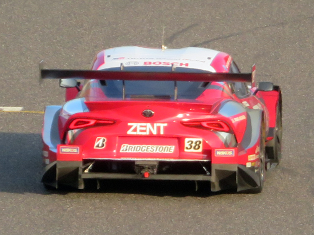 Ein rotes Sportauto mit Text und Zahlen, das an den 24 Stunden von Le Mans teilnimmt, fährt auf einer Rennstrecke.